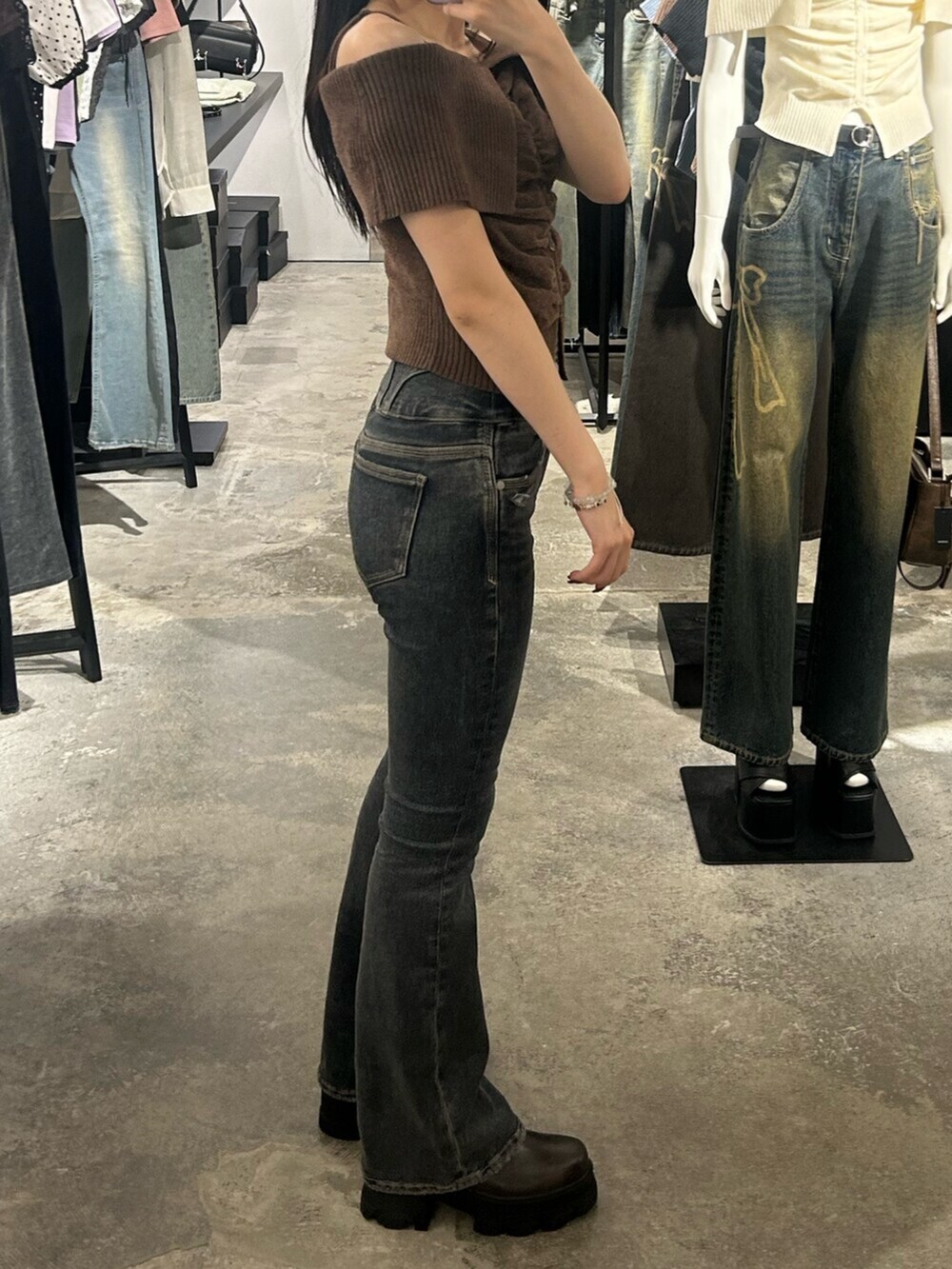 ブラウン系のブーツ、ブラウン系のニット/セーター、ブルー系のデニムパンツを着用したレディースの夏コーディネートの2枚目の写真