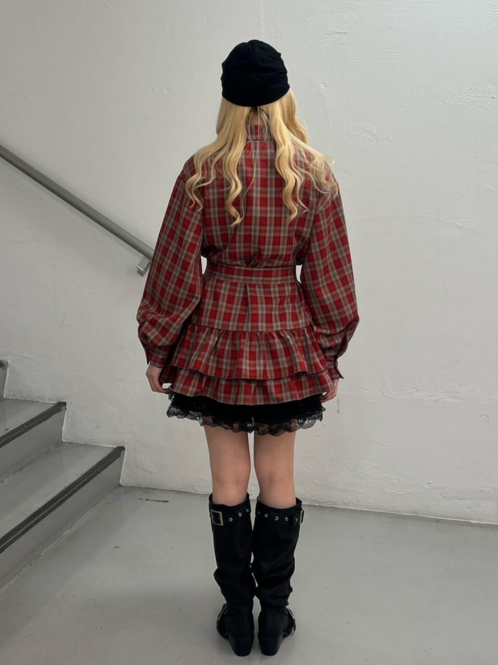 レッド系のワンピース、ブラック系のその他パンツ、ブラック系のブーツを着用したレディースの冬コーディネートの3枚目の写真