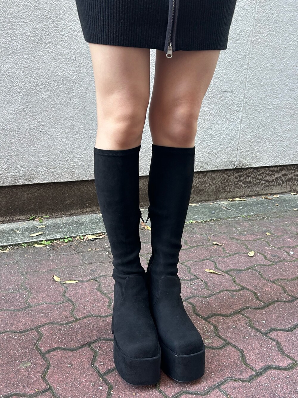 ホワイト系のブルゾン、ブラック系のワンピース、シルバー系のショルダーバッグを着用したレディースの秋コーディネートの6枚目の写真