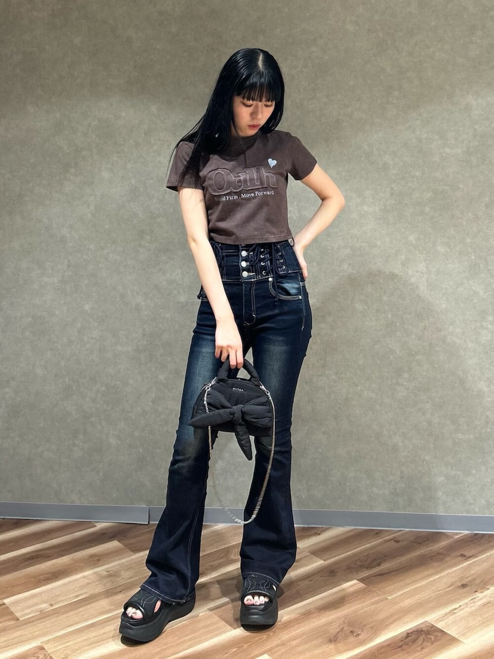 ブラック系のサンダル、ブラウン系のTシャツ/カットソー、ブルー系のデニムパンツを着用したレディースの夏コーディネートの2枚目の写真