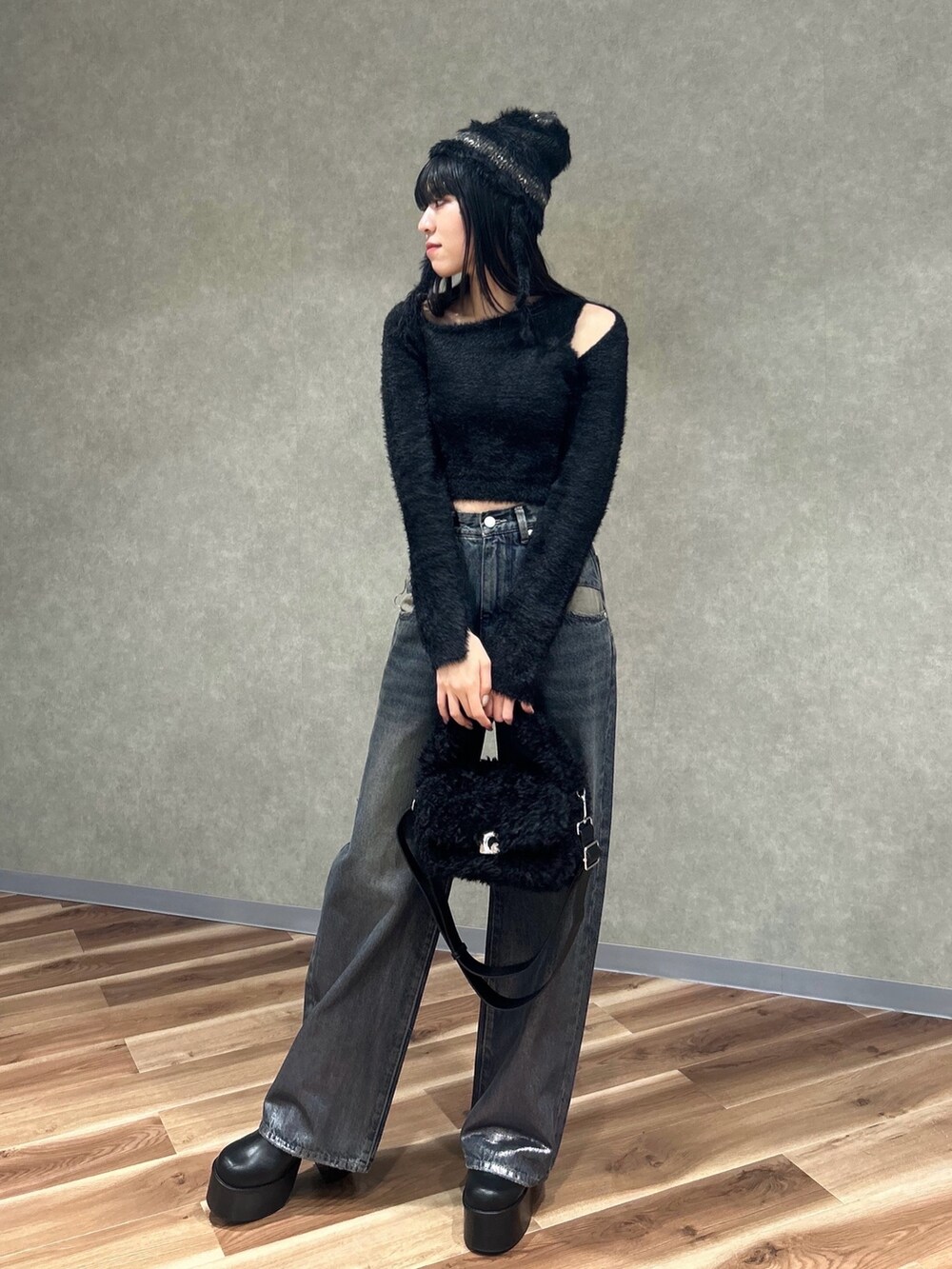 ブラック系のニット/セーター、ブラック系のブーツ、ブラック系のハンドバッグを着用したレディースの冬コーディネートの2枚目の写真