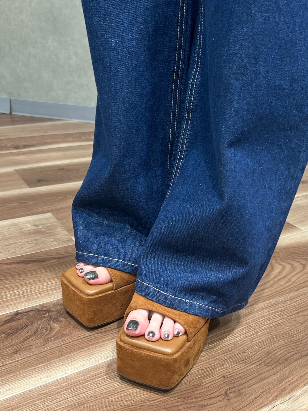 グレー系のワンピース、グレー系のハンドバッグ、ブルー系のデニムパンツを着用したレディースの夏コーディネートの7枚目の写真