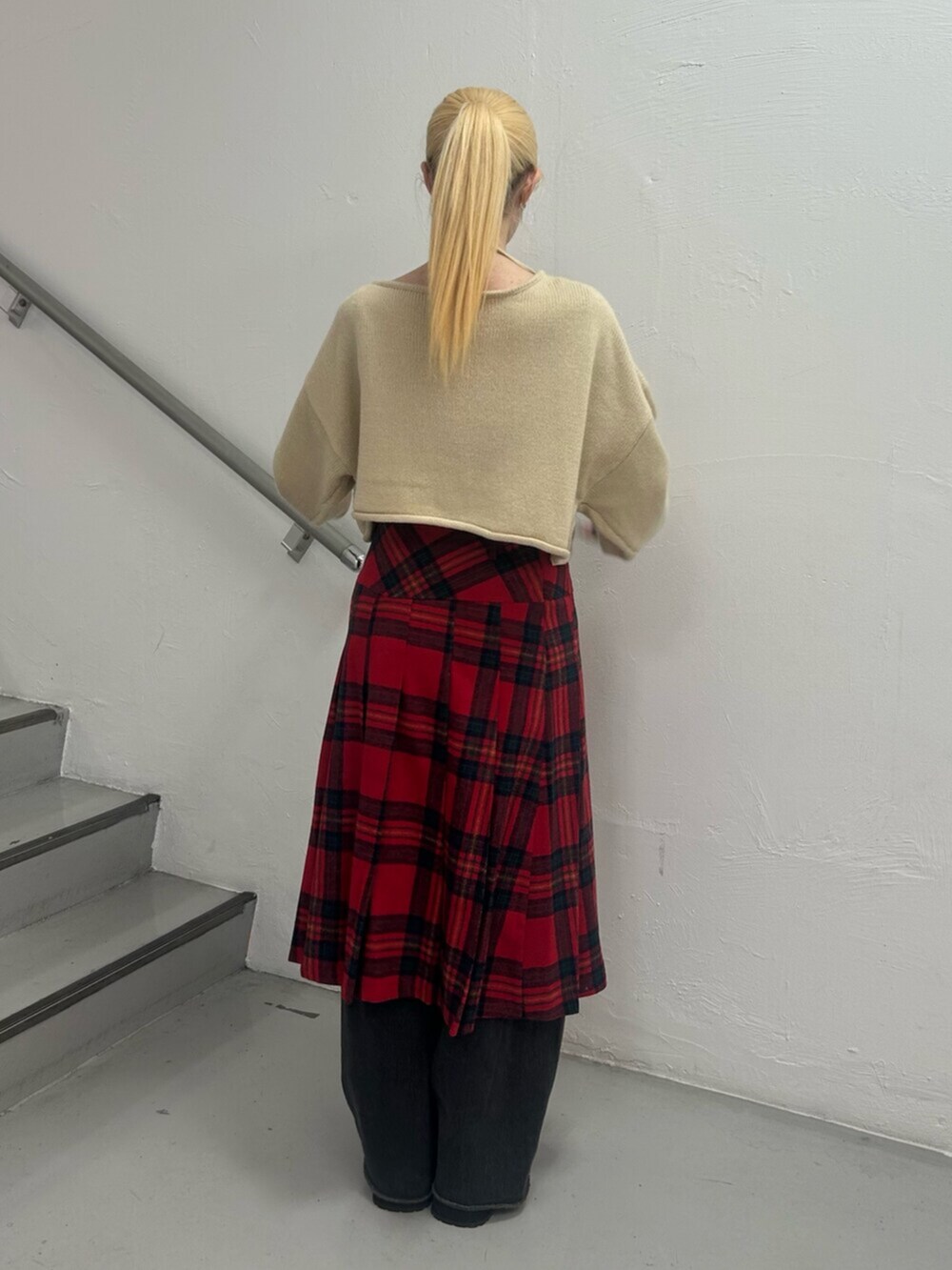 ブラック系のデニムパンツ、ブラウン系のブーツ、ホワイト系のニット/セーターを着用したレディースの冬コーディネートの4枚目の写真
