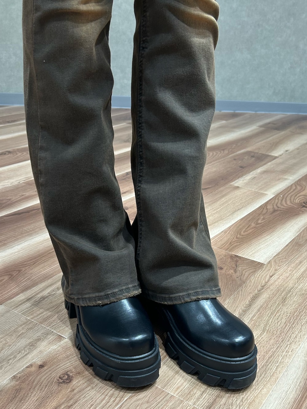 ホワイト系のブルゾン、ブラック系のブーツ、ブラック系のニット/セーターを着用したレディースの冬コーディネートの7枚目の写真