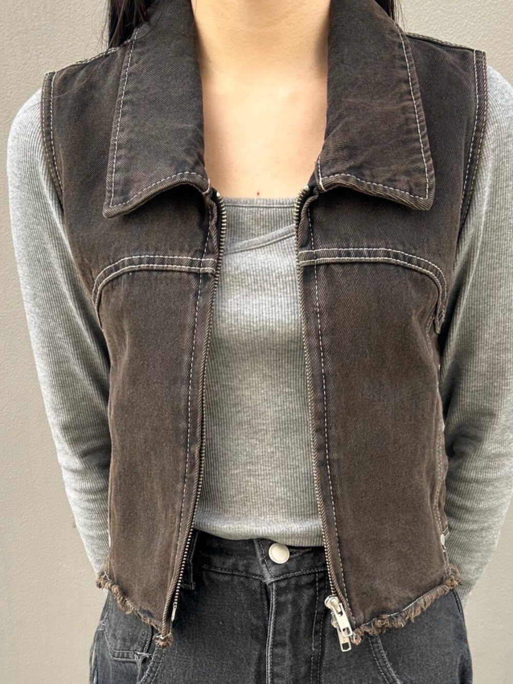 ブラック系のハンドバッグ、グレー系のTシャツ/カットソー、ブラック系のベストを着用したレディースの春コーディネートの5枚目の写真