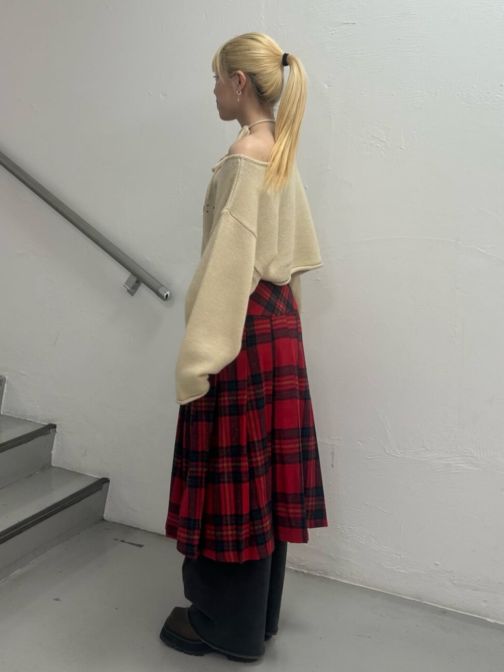 ブラック系のデニムパンツ、ブラウン系のブーツ、ホワイト系のニット/セーターを着用したレディースの冬コーディネートの3枚目の写真
