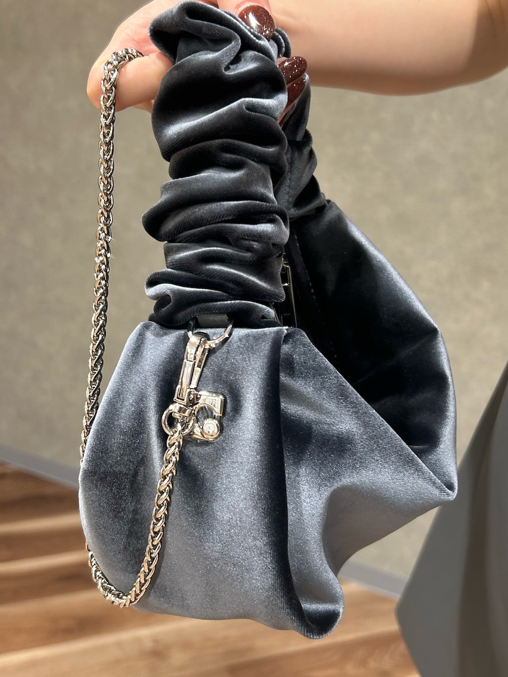 グレー系のワンピース、グレー系のハンドバッグ、ブルー系のデニムパンツを着用したレディースの夏コーディネートの9枚目の写真