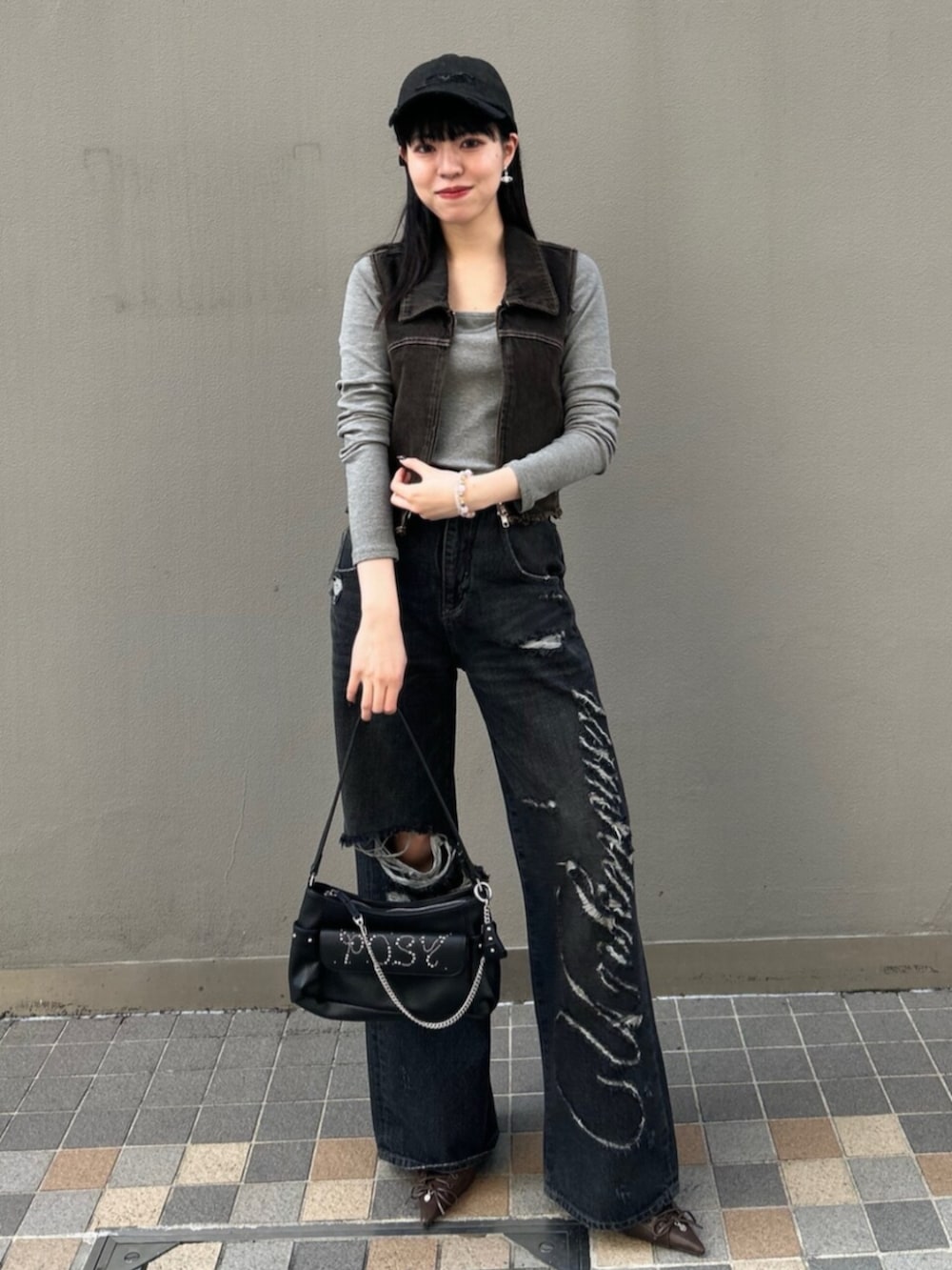 ブラック系のハンドバッグ、グレー系のTシャツ/カットソー、ブラック系のベストを着用したレディースの春コーディネートの2枚目の写真