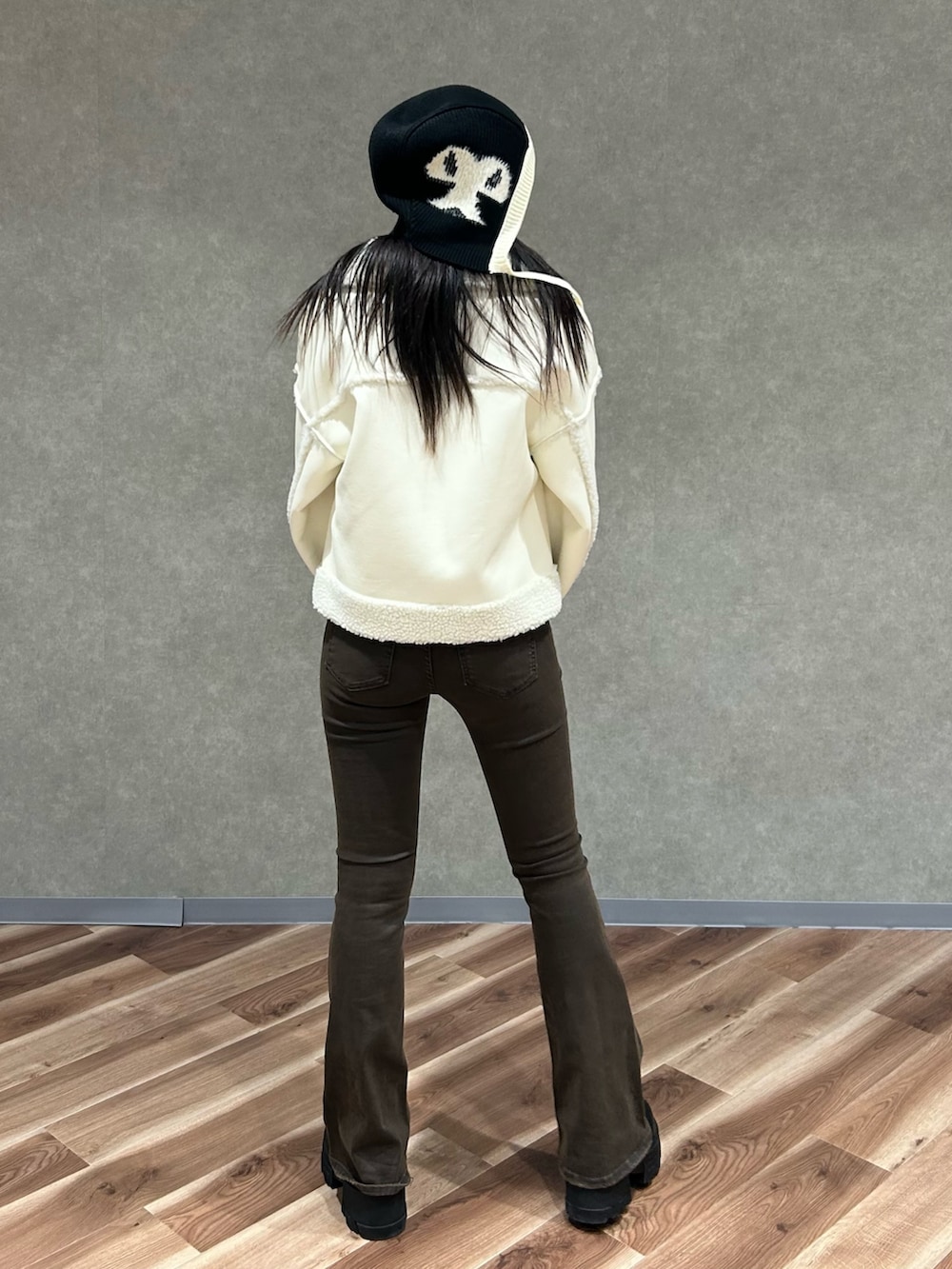 ホワイト系のブルゾン、ブラック系のブーツ、ブラック系のニット/セーターを着用したレディースの冬コーディネートの4枚目の写真