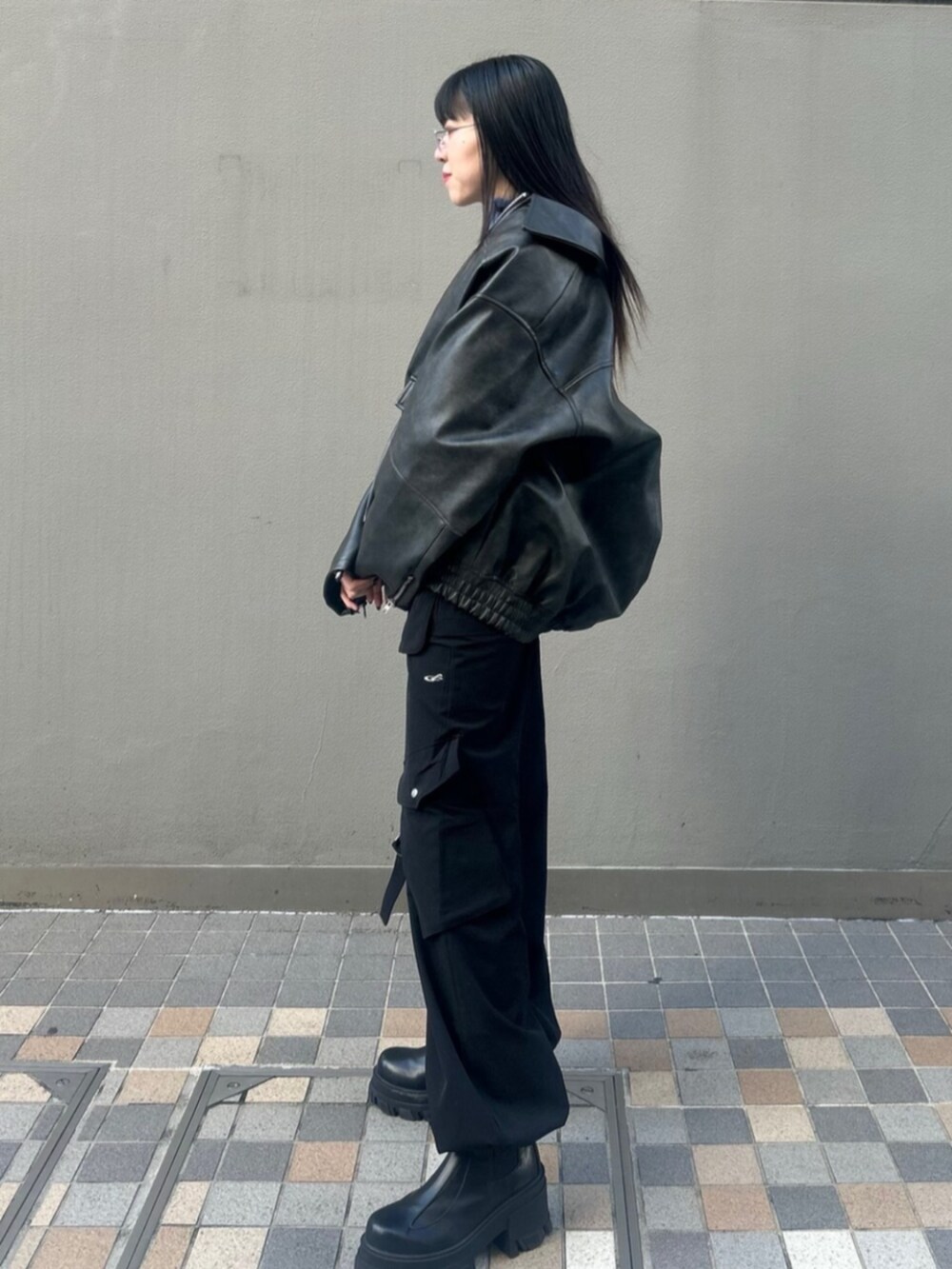 ブラック系のブーツ、ブラック系のブルゾン、ブルー系のニット/セーターを着用したレディースの冬コーディネートの3枚目の写真