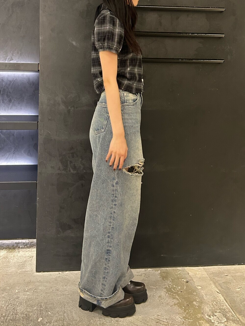 ブラウン系のブーツ、ブラック系のTシャツ/カットソー、ブルー系のデニムパンツを着用したレディースの夏コーディネートの2枚目の写真