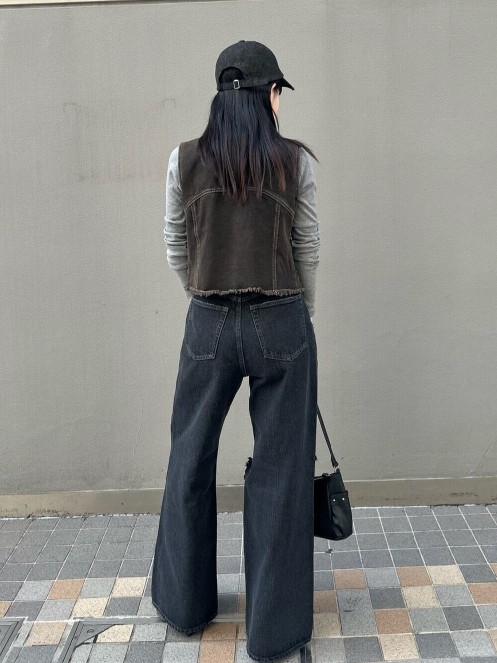 ブラック系のハンドバッグ、グレー系のTシャツ/カットソー、ブラック系のベストを着用したレディースの春コーディネートの4枚目の写真