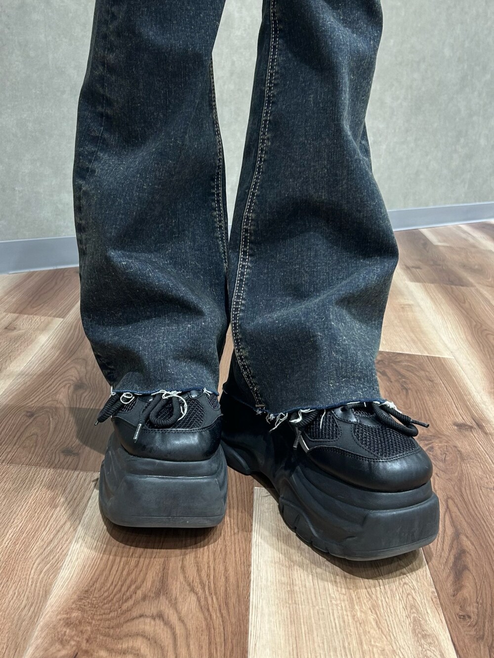 ブラック系のニット/セーター、ブラウン系のTシャツ/カットソー、ブルー系のデニムパンツを着用したレディースの春コーディネートの6枚目の写真