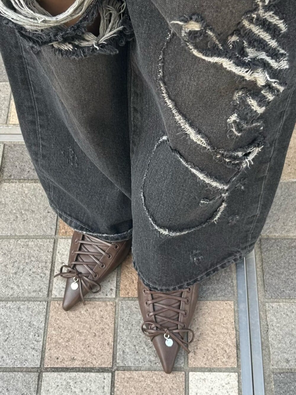 ブラック系のハンドバッグ、グレー系のTシャツ/カットソー、ブラック系のベストを着用したレディースの春コーディネートの7枚目の写真