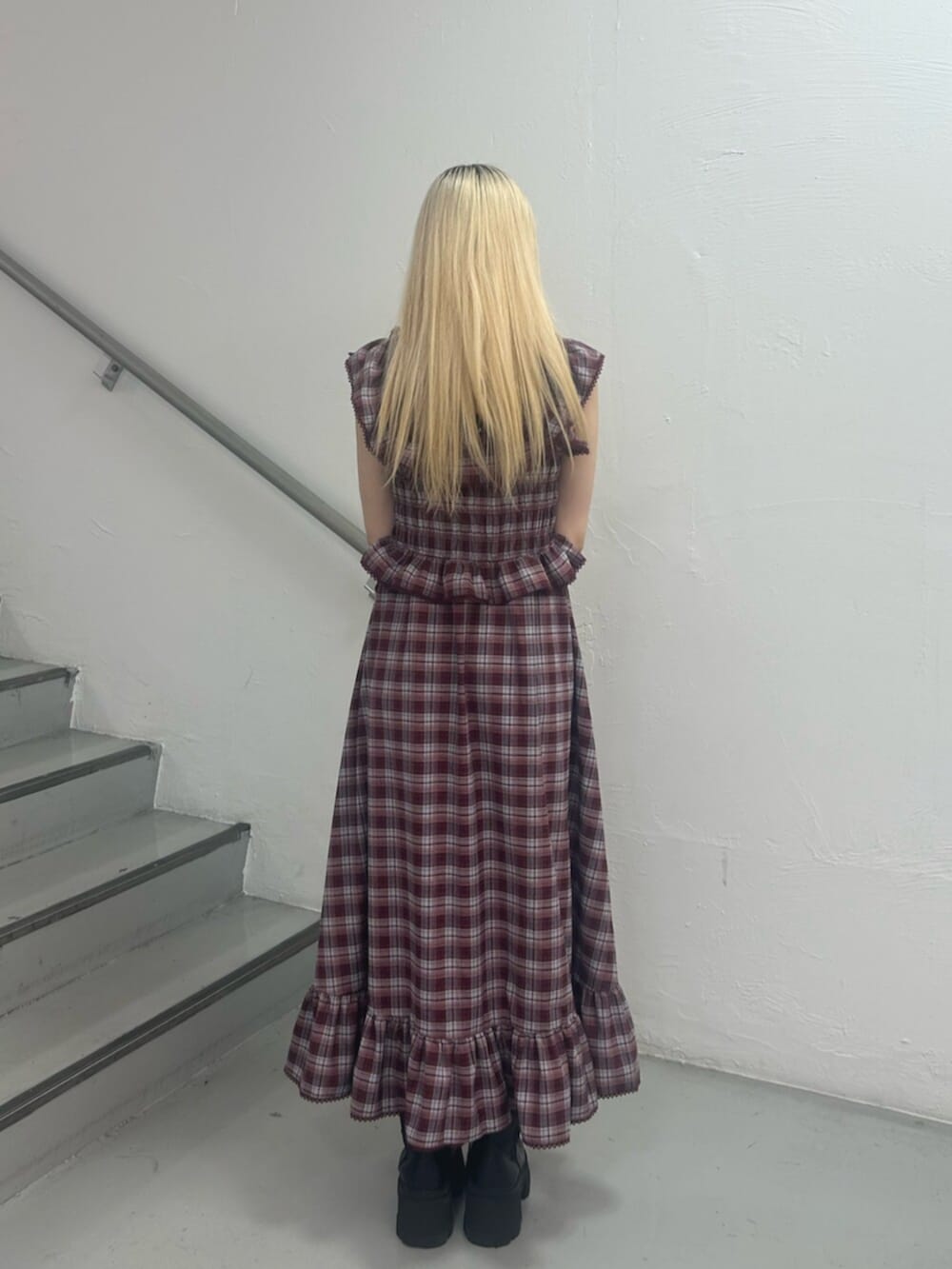 ブラック系のハンドバッグ、レッド系のワンピース、シルバー系のネックレスを着用したレディースの春コーディネートの4枚目の写真