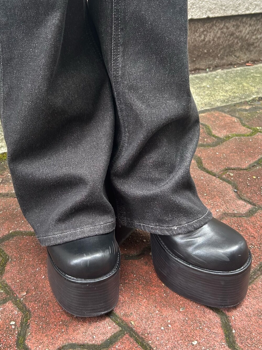 ブラック系のニット/セーター、ブラック系のブーツ、ブラック系のハンドバッグを着用したレディースの冬コーディネートの7枚目の写真