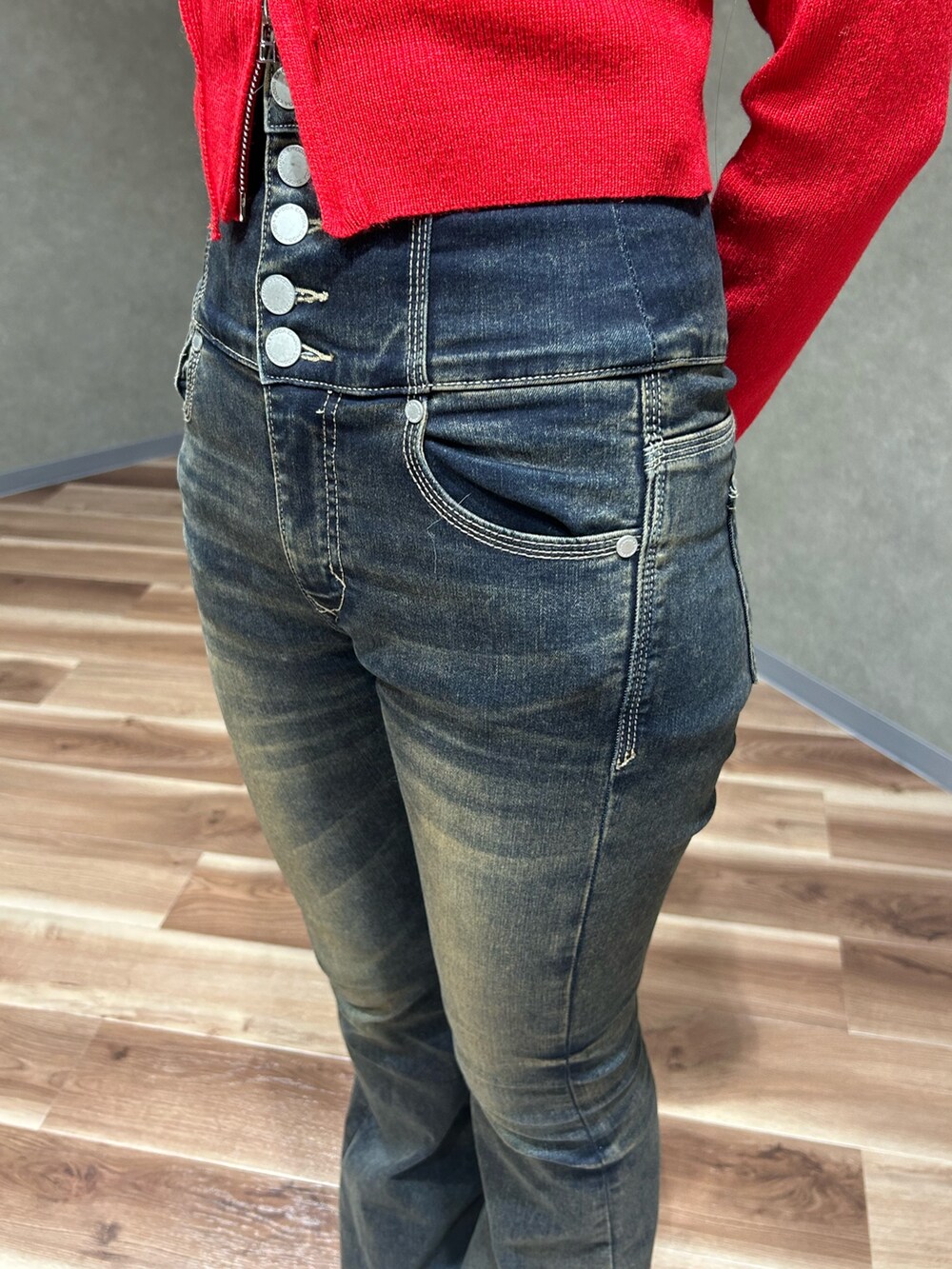 レッド系のニット/セーター、ブルー系のデニムパンツ、ブラック系のショルダーバッグを着用したレディースの秋コーディネートの6枚目の写真