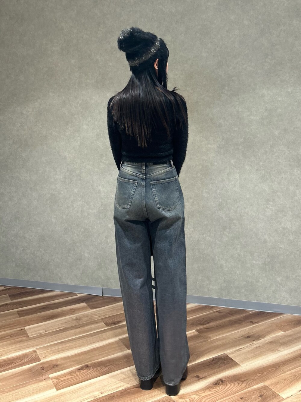 ブラック系のニット/セーター、ブラック系のブーツ、ブラック系のハンドバッグを着用したレディースの冬コーディネートの4枚目の写真