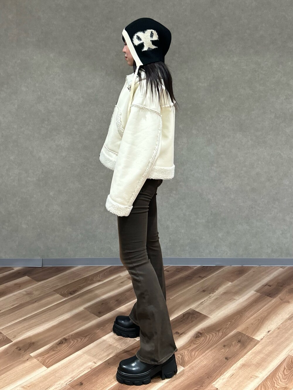 ホワイト系のブルゾン、ブラック系のブーツ、ブラック系のニット/セーターを着用したレディースの冬コーディネートの3枚目の写真