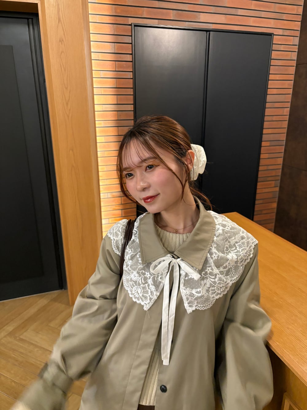 ブラウン系のシューズ、ブラウン系のスカート、グリーン系のトレンチコートを着用したレディースの春コーディネートの2枚目の写真