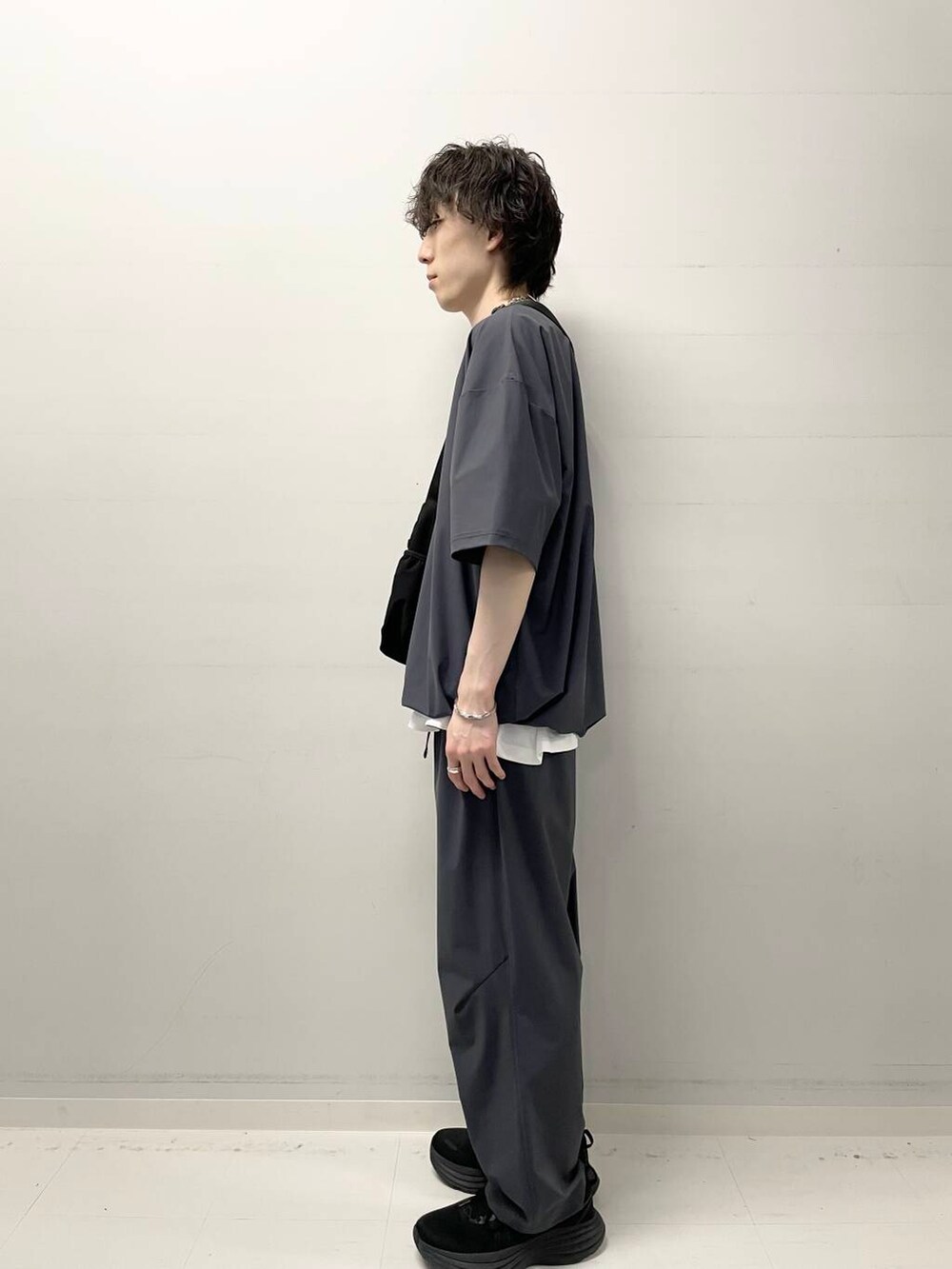 ブラック系のショルダーバッグ、ホワイト系のTシャツ/カットソー、グレー系のTシャツ/カットソーを着用したメンズの春コーディネートの2枚目の写真