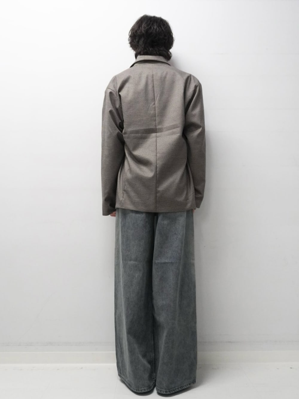 ブルー系のデニムパンツ、レッド系のニット/セーター、ブラウン系のその他アウターを着用したメンズの秋コーディネートの3枚目の写真