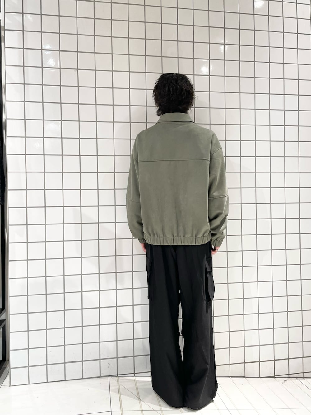 ブラック系のカーゴパンツ、グリーン系のブルゾン、ブラック系のTシャツ/カットソーを着用したメンズの冬コーディネートの3枚目の写真