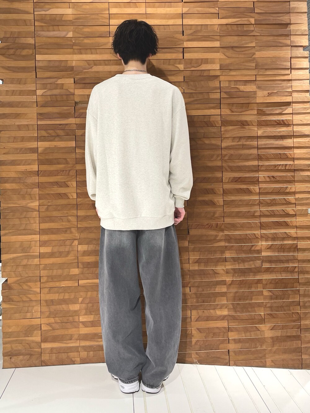 ベージュ系のスウェット、グレー系のデニムパンツを着用したメンズの秋コーディネートの3枚目の写真