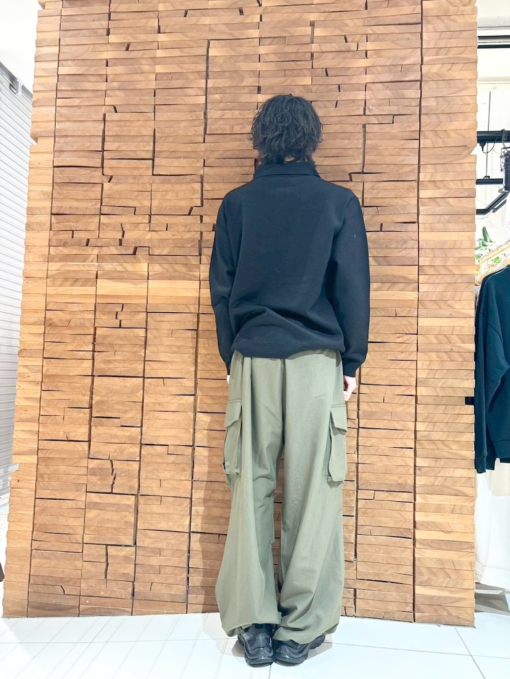 ブラック系のニット/セーター、グリーン系のカーゴパンツを着用したメンズの冬コーディネートの3枚目の写真