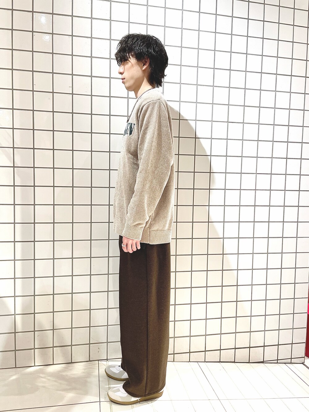 ベージュ系のニット/セーター、ブラウン系のその他パンツ、ホワイト系のスニーカーを着用したメンズの冬コーディネートの2枚目の写真