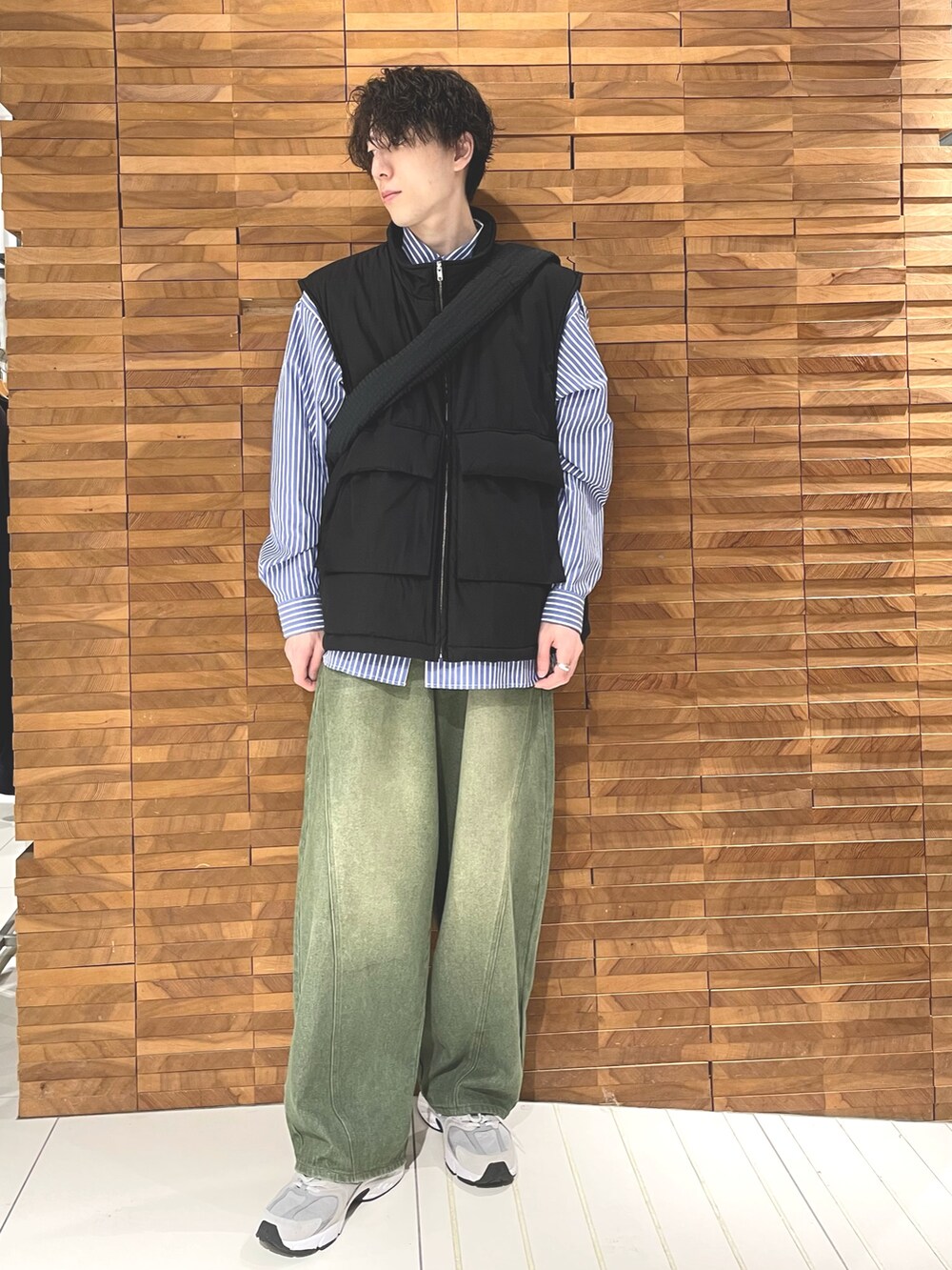 ブラック系のダウンベスト、ブルー系のシャツ/ブラウス、ブラック系のショルダーバッグを着用したメンズの秋コーディネートの2枚目の写真