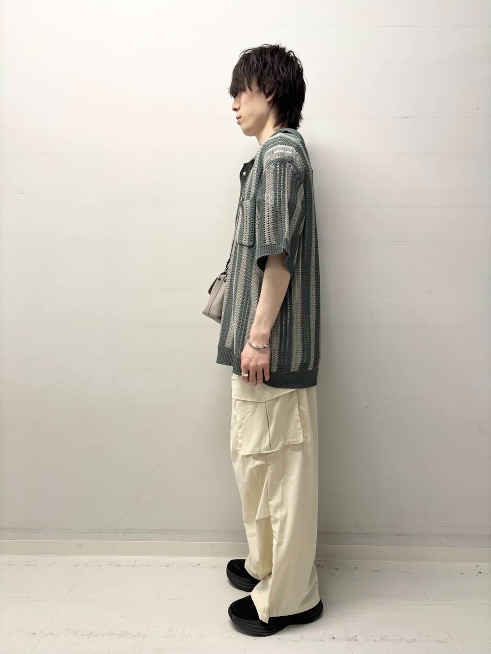 ホワイト系のTシャツ/カットソー、ベージュ系のその他パンツ、グレー系のボディバッグ/ウエストポーチを着用したメンズの春コーディネートの2枚目の写真