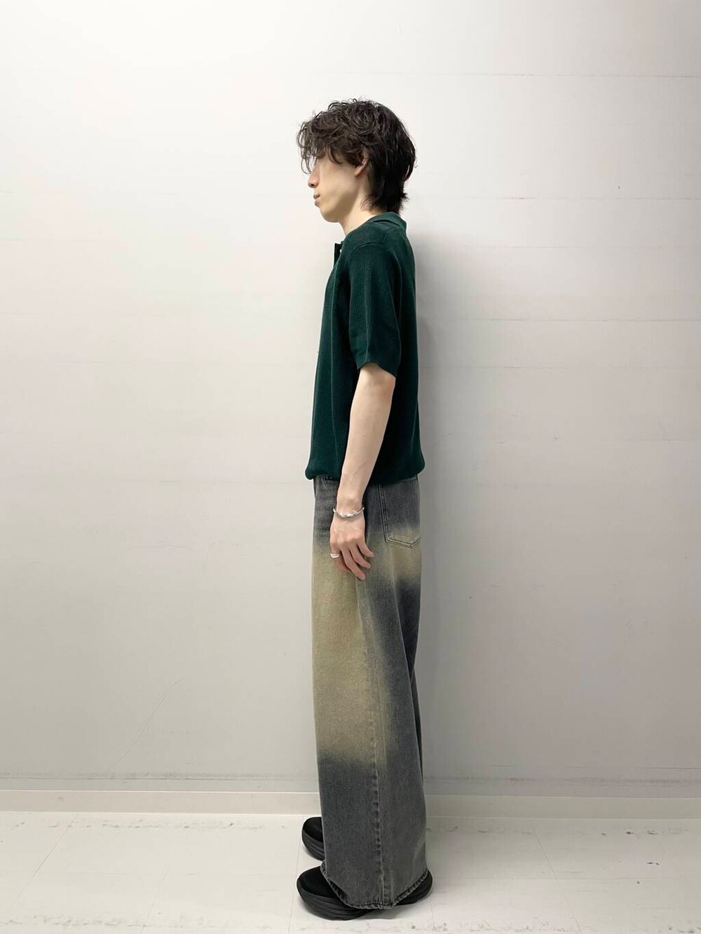 ブルー系のデニムパンツ、グリーン系のニット/セーターを着用したメンズの夏コーディネートの2枚目の写真