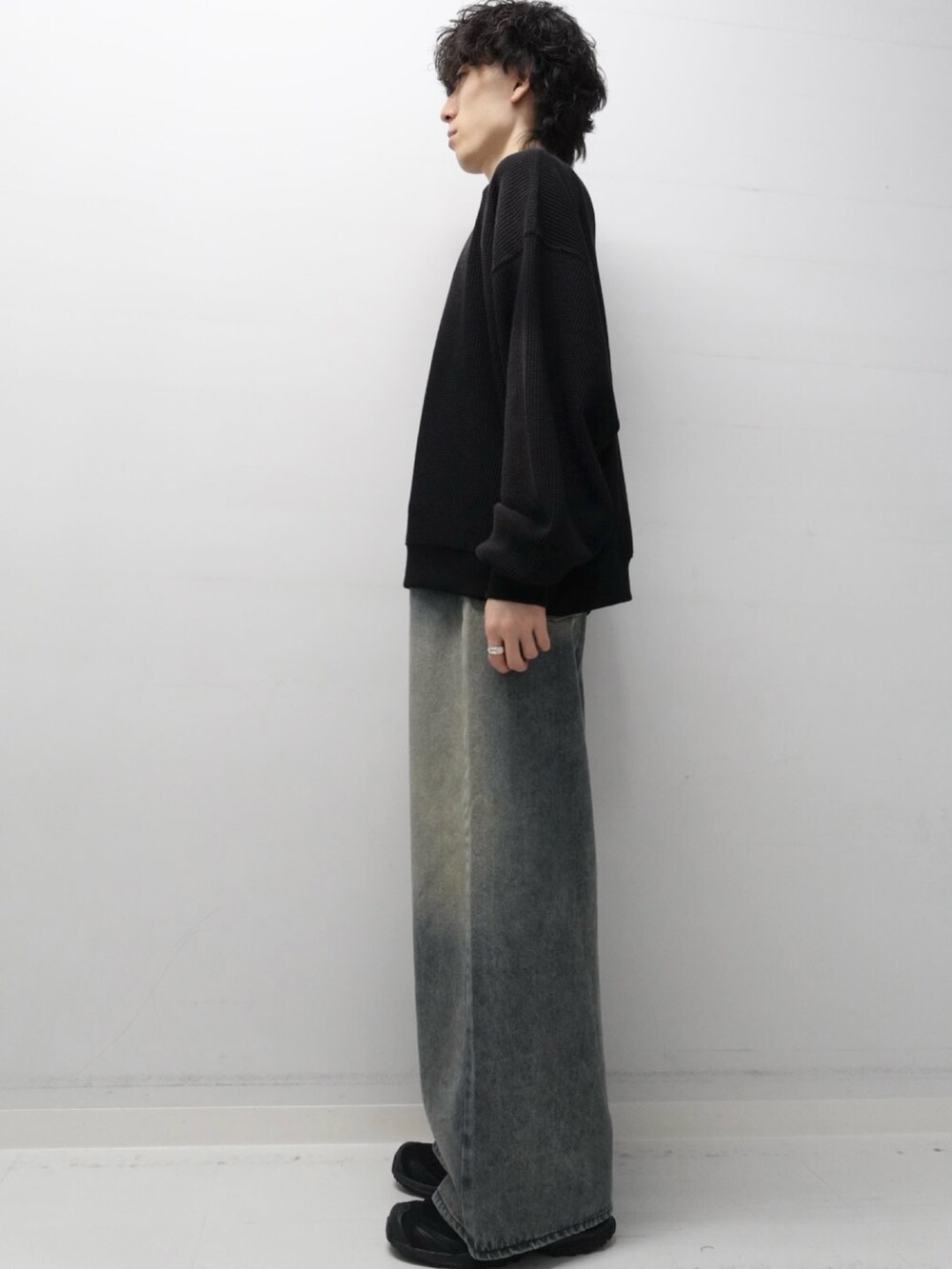 ブルー系のデニムパンツ、ブラック系のスウェットを着用したメンズの秋コーディネートの2枚目の写真