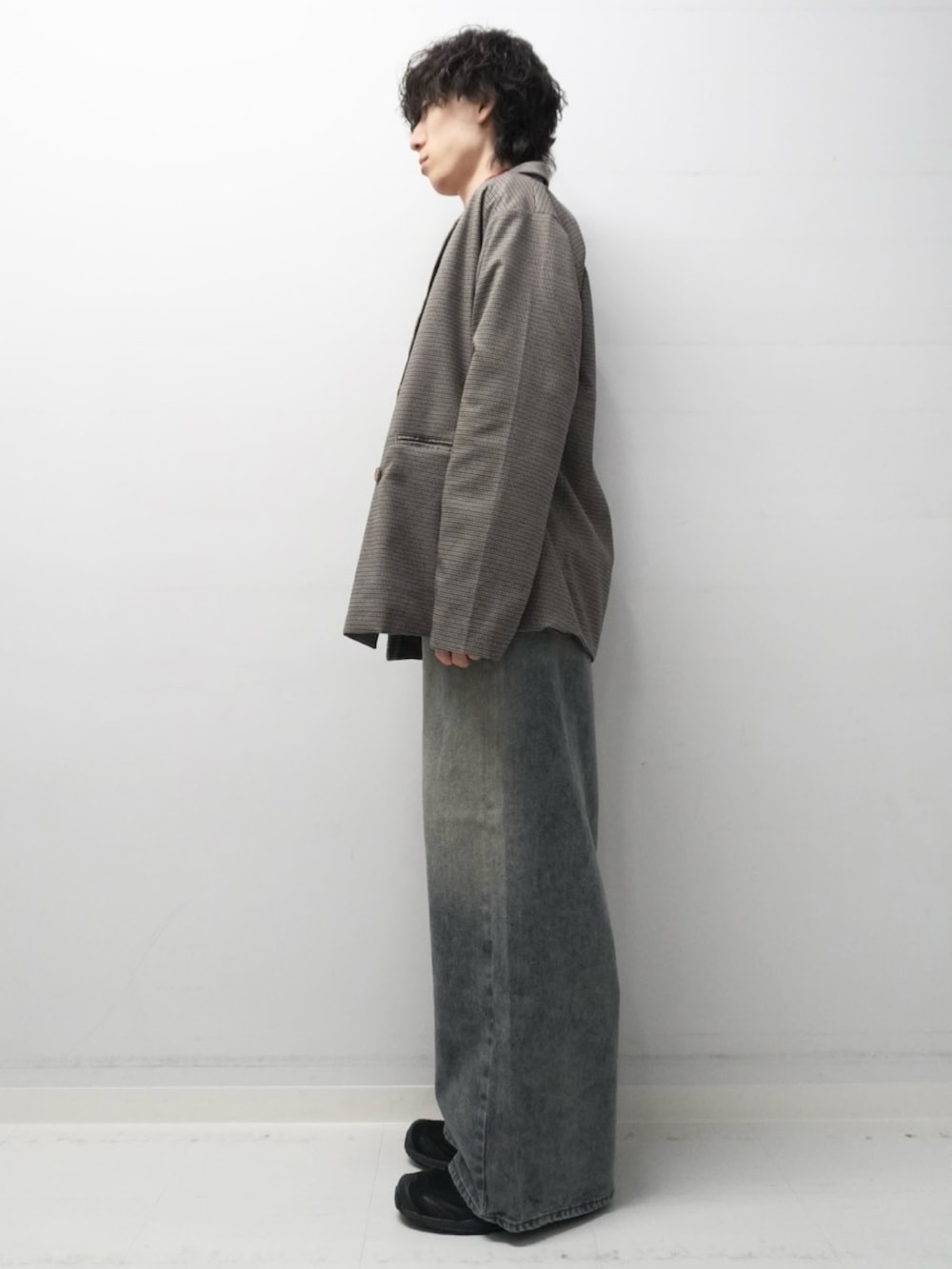 ブルー系のデニムパンツ、レッド系のニット/セーター、ブラウン系のその他アウターを着用したメンズの秋コーディネートの2枚目の写真