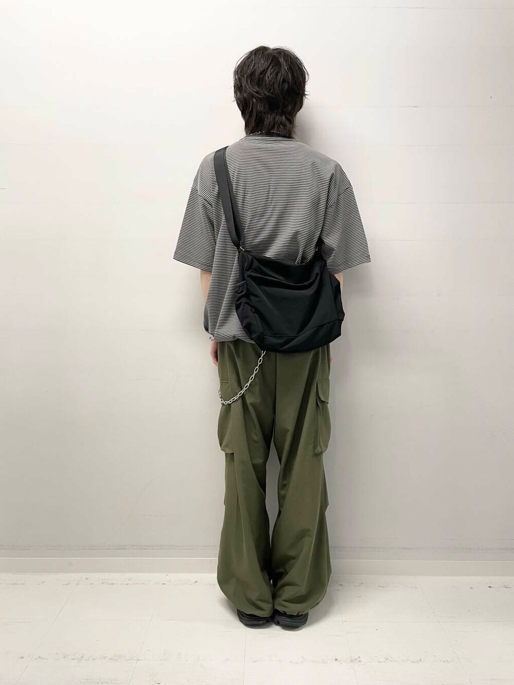 グリーン系のその他パンツ、ブラック系のショルダーバッグ、グリーン系のTシャツ/カットソーを着用したメンズの春コーディネートの3枚目の写真