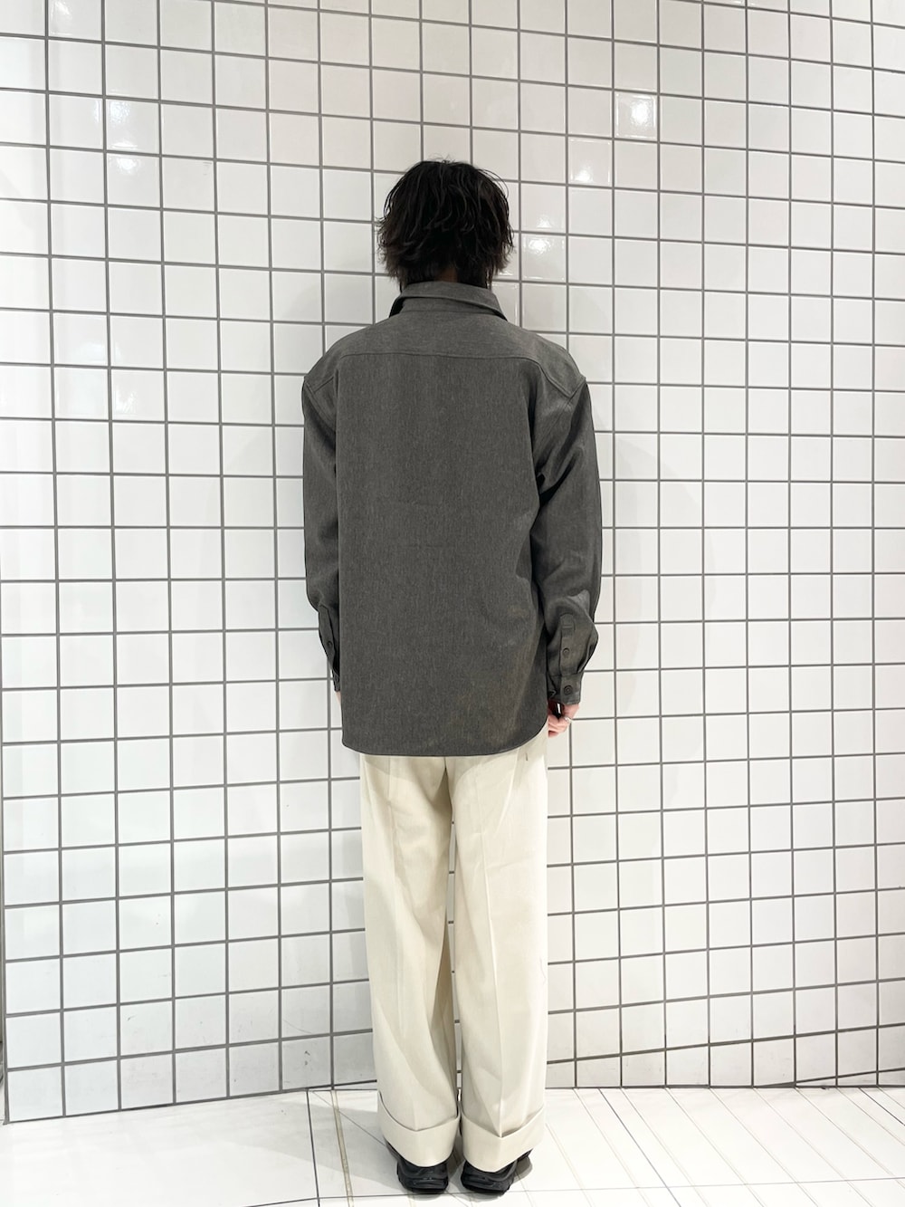 ベージュ系のスラックス、グリーン系のシャツ/ブラウス、ブラック系のニット/セーターを着用したメンズの冬コーディネートの3枚目の写真