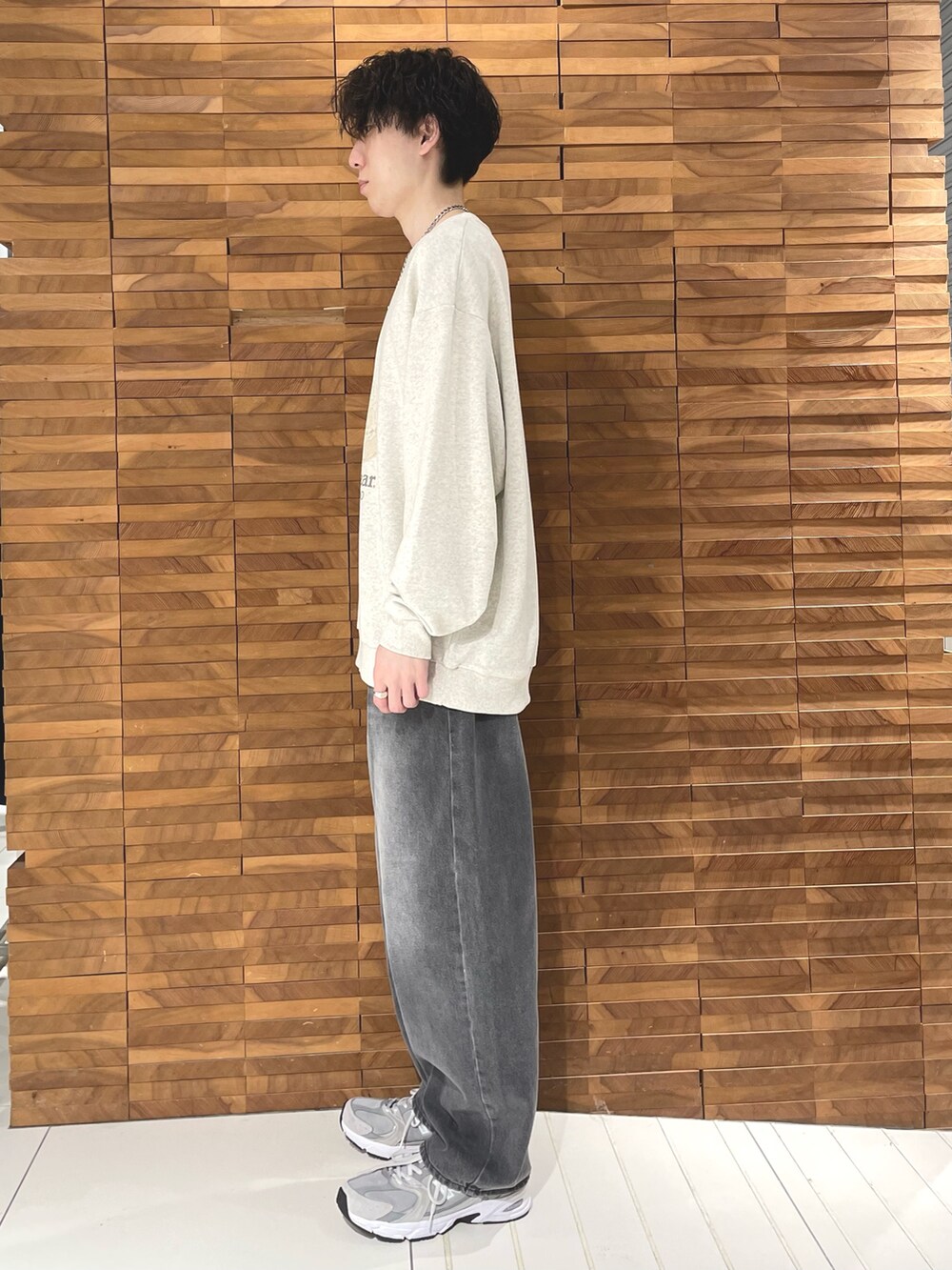 ベージュ系のスウェット、グレー系のデニムパンツを着用したメンズの秋コーディネートの2枚目の写真