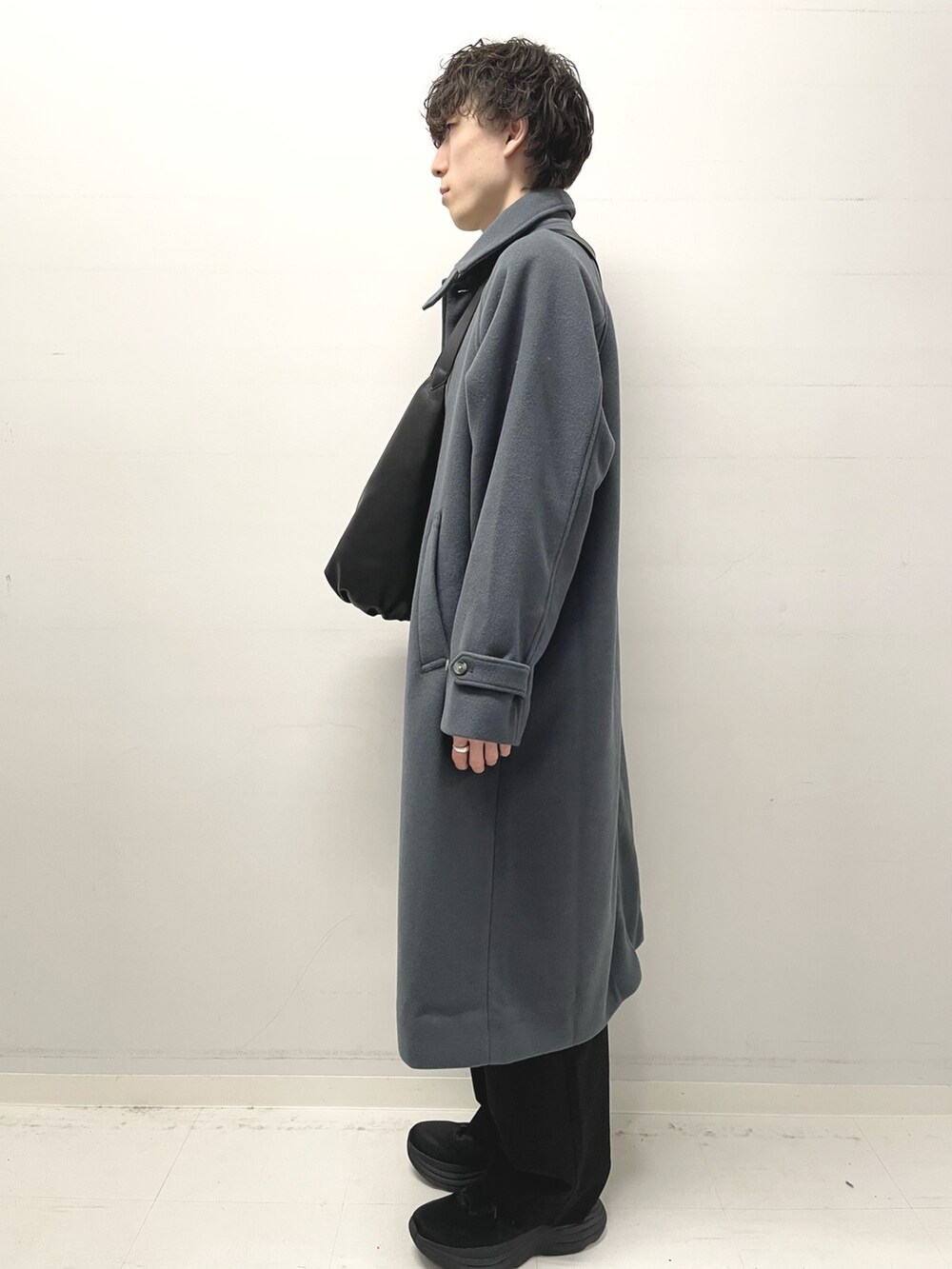 ホワイト系のニット/セーター、ブルー系のステンカラーコート、ブラック系のその他パンツを着用したメンズの冬コーディネートの2枚目の写真