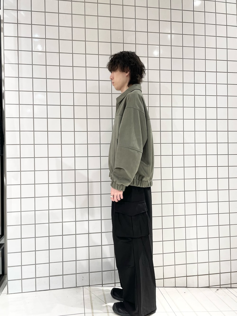 ブラック系のカーゴパンツ、グリーン系のブルゾン、ブラック系のTシャツ/カットソーを着用したメンズの冬コーディネートの2枚目の写真