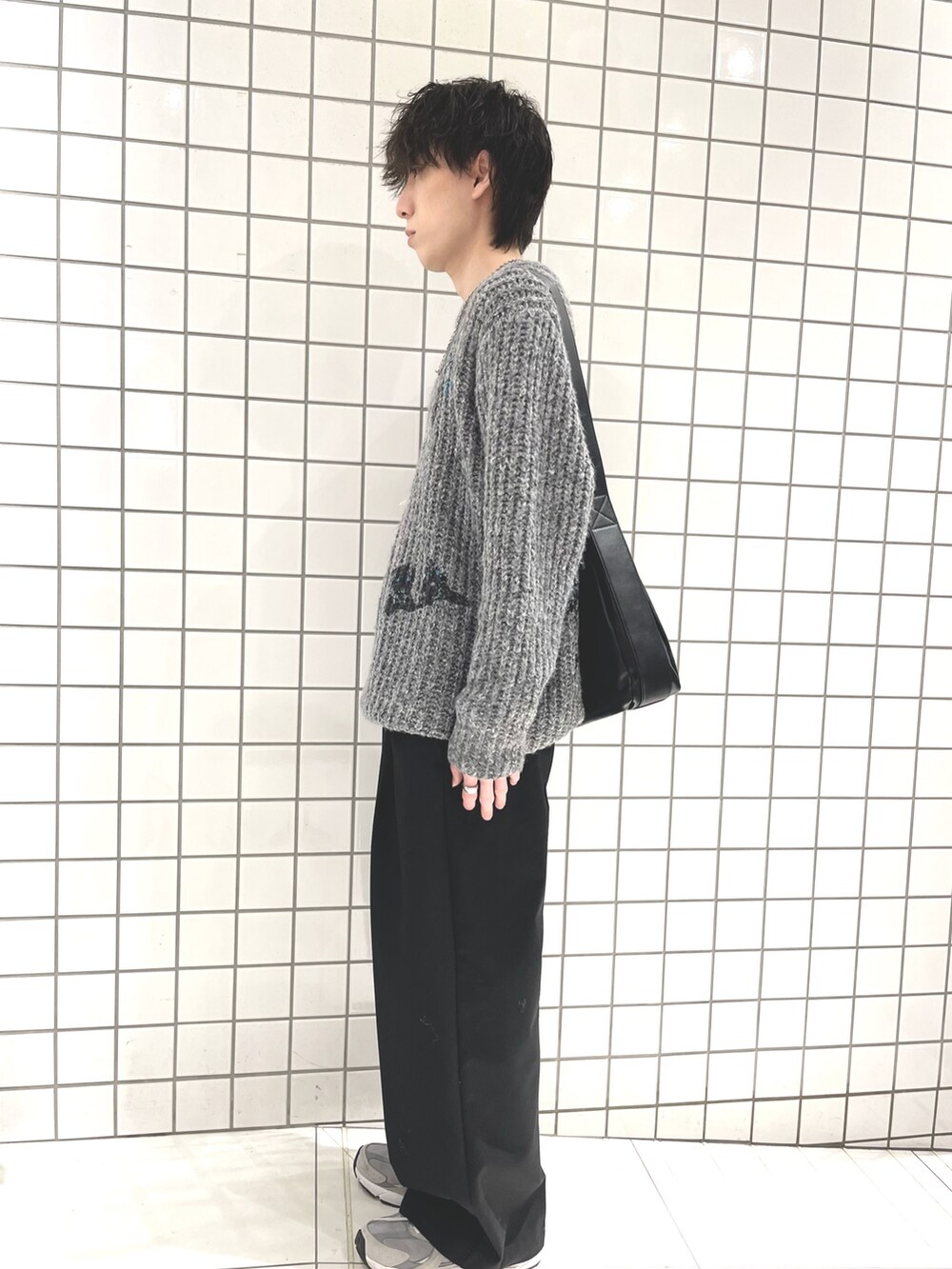 グレー系のニット/セーター、ブラック系のショルダーバッグを着用したメンズの冬コーディネートの2枚目の写真