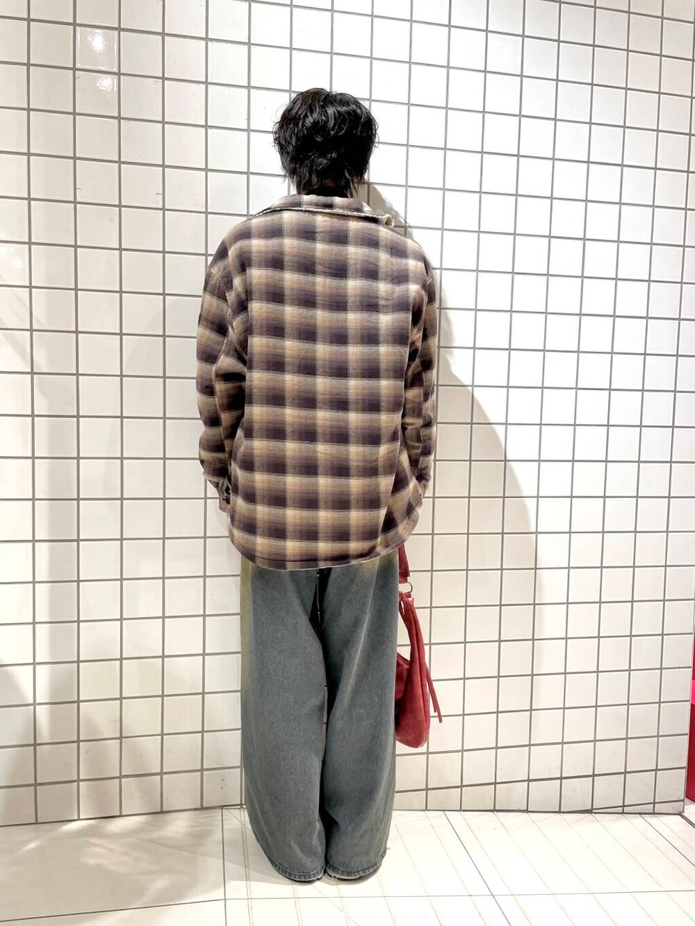 ブラック系のニット/セーター、ブルー系のデニムパンツ、ブラウン系のその他アウターを着用したメンズの冬コーディネートの3枚目の写真