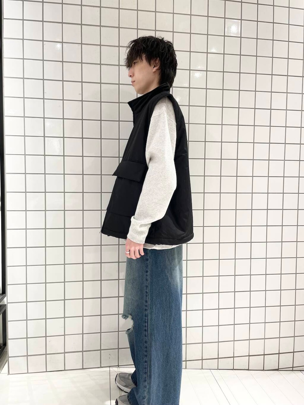 ブラック系のダウンベスト、ブルー系のデニムパンツ、グレー系のスウェットを着用したメンズの冬コーディネートの2枚目の写真