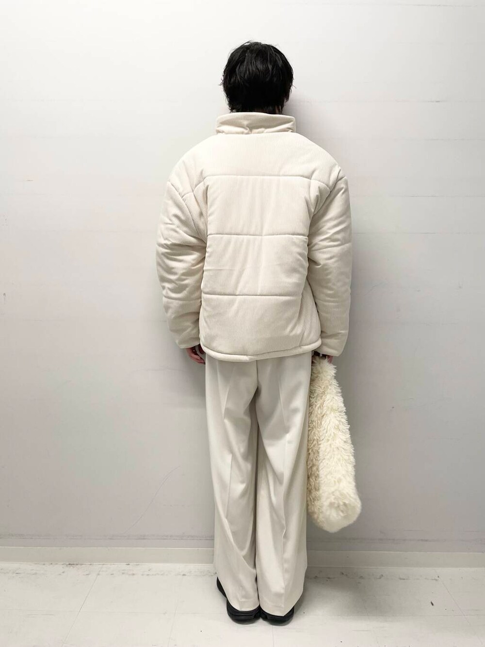 ホワイト系のニット/セーター、ホワイト系のダウンジャケット/コート、ホワイト系のトートバッグを着用したメンズの冬コーディネートの3枚目の写真