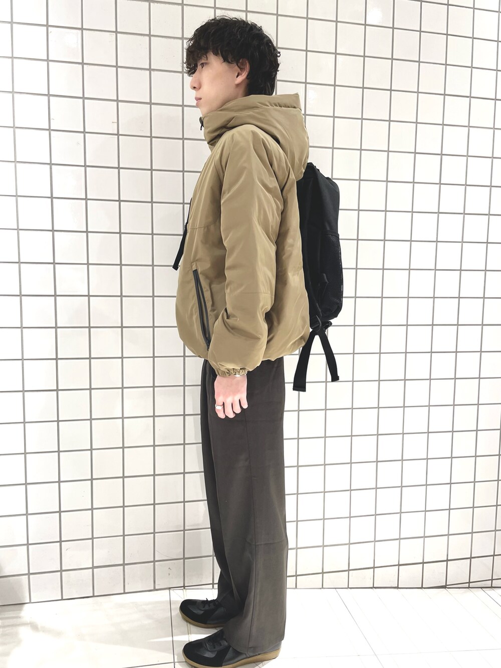 グレー系のその他パンツ、ブラック系のスニーカー、ブラック系のバックパック/リュックを着用したメンズの冬コーディネートの2枚目の写真