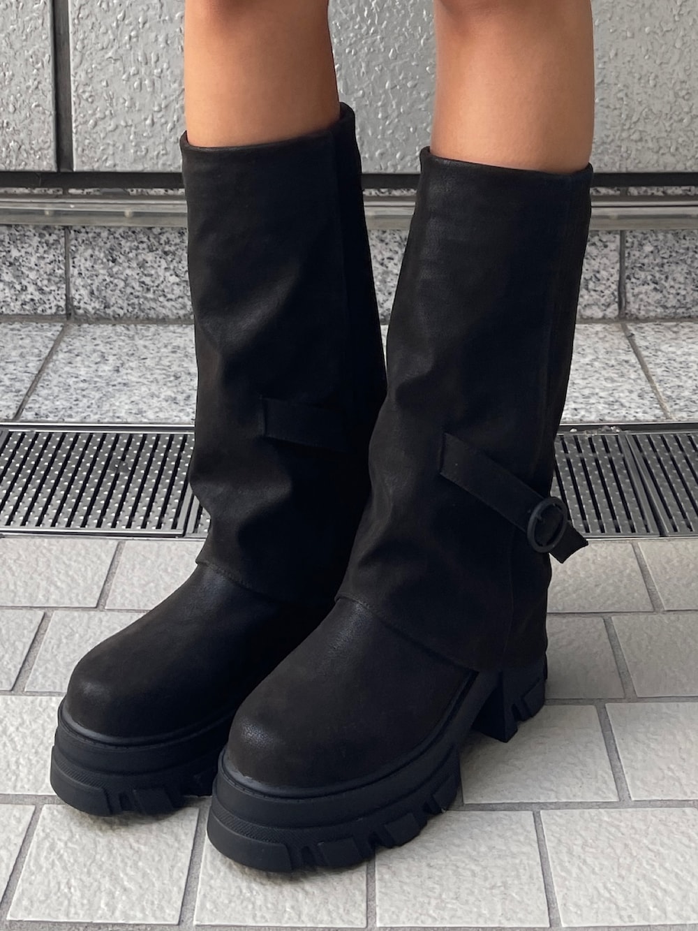 グレー系のパーカー、グレー系のスカート、ブラック系のブーツを着用したレディースの秋コーディネートの5枚目の写真