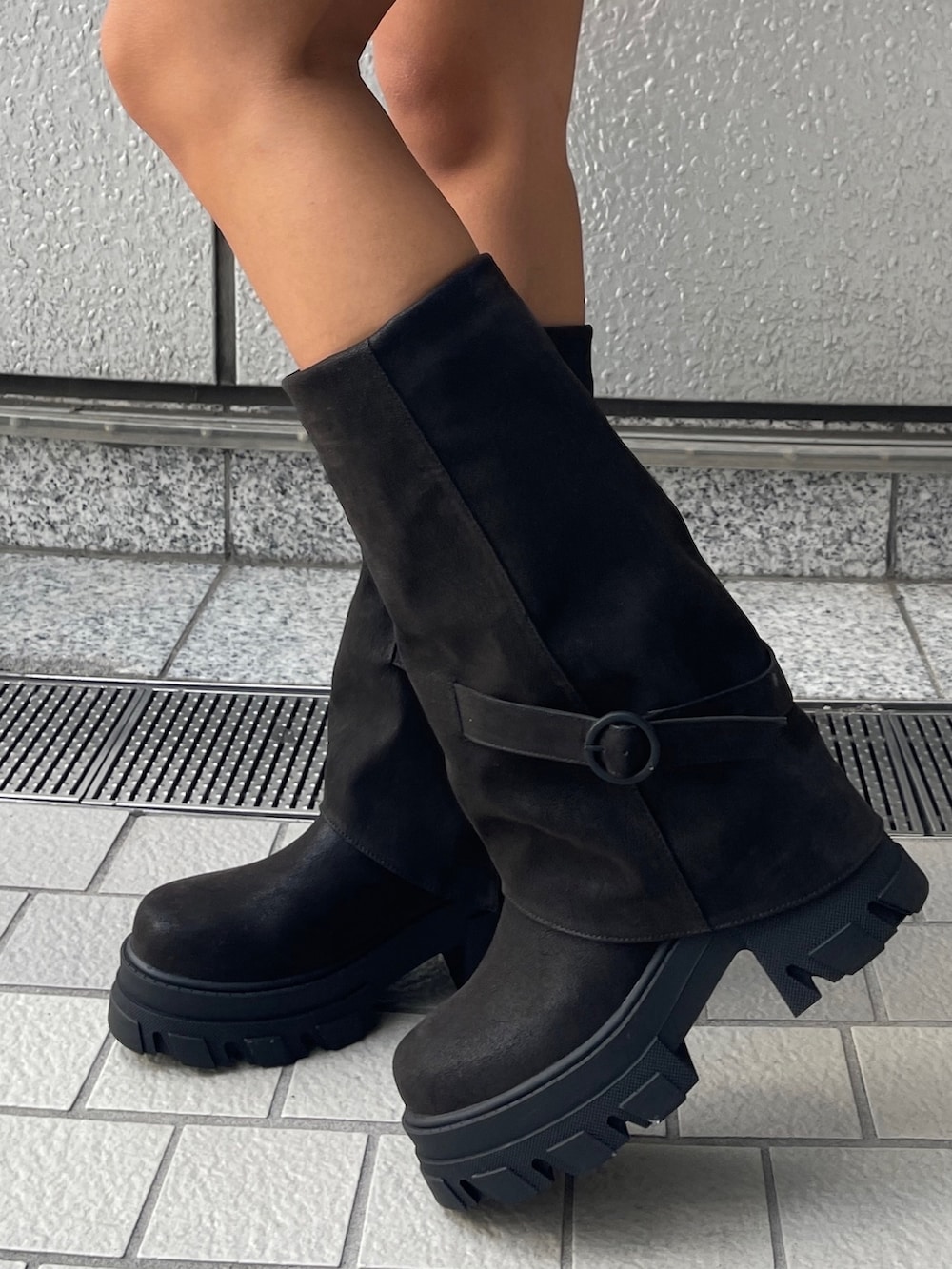 グレー系のパーカー、グレー系のスカート、ブラック系のブーツを着用したレディースの秋コーディネートの6枚目の写真