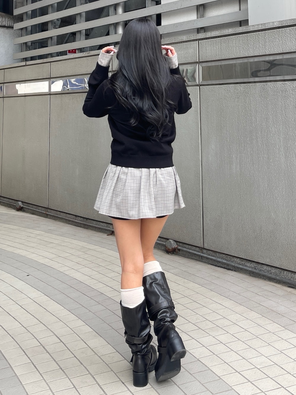 ブラック系のスカート、ブラック系のシャツ/ブラウス、ブラック系のブーツを着用したレディースの春コーディネートの3枚目の写真