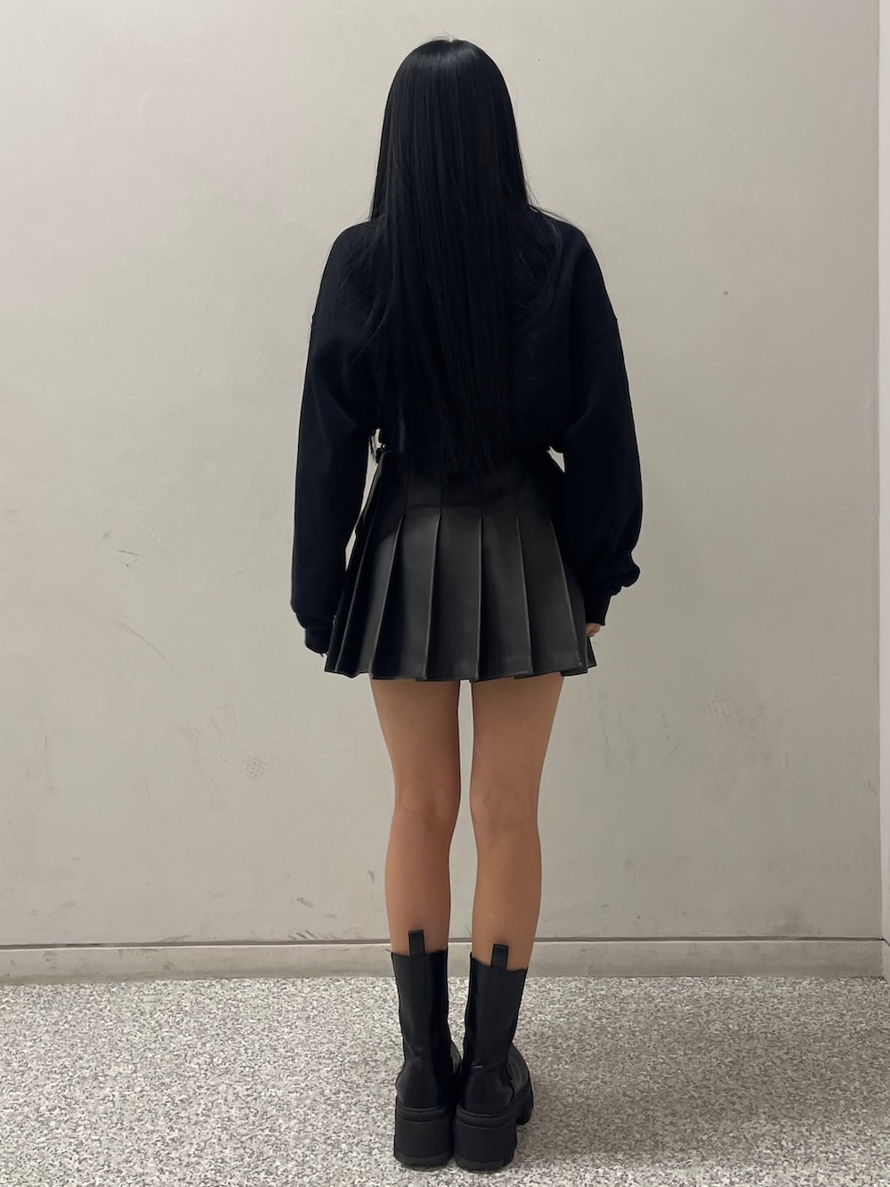 ブラック系のTシャツ/カットソー、ブラック系のスカート、ブラック系のブーツを着用したレディースの冬コーディネートの2枚目の写真