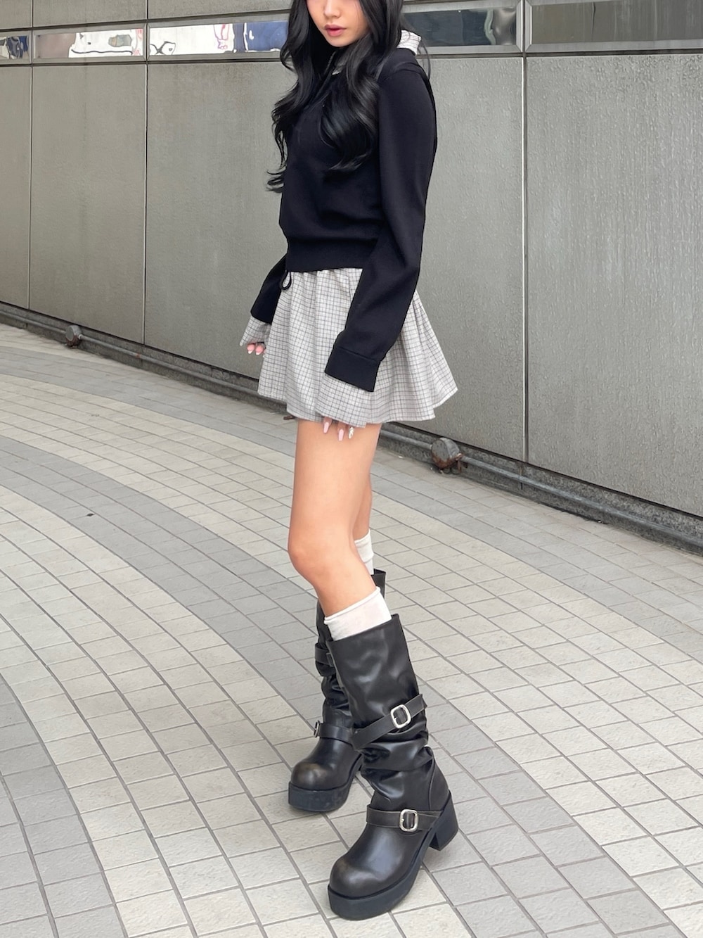 ブラック系のスカート、ブラック系のシャツ/ブラウス、ブラック系のブーツを着用したレディースの春コーディネートの2枚目の写真